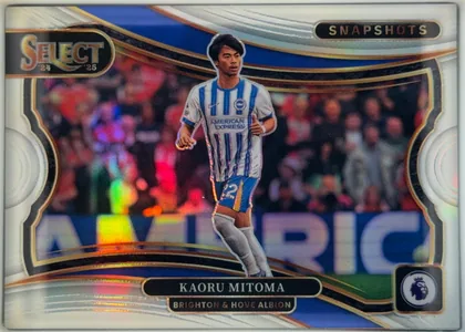 Front of 2024-25 Panini Select Premier League Soccer Kaoru Mitoma #8 Prizm, upright landscape soccer card. A central action photograph shows Kaoru Mitoma in a Brighton & Hove Albion blue-and-white striped kit running on the…