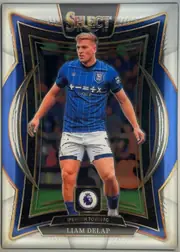 Front of 2024-25 Panini Select Premier League Soccer LIAM DELAP #20, front of a portrait football card. A footballer in a blue Ipswich Town FC kit is pictured centrally. The top has a large SELECT title with 24 and 25…
