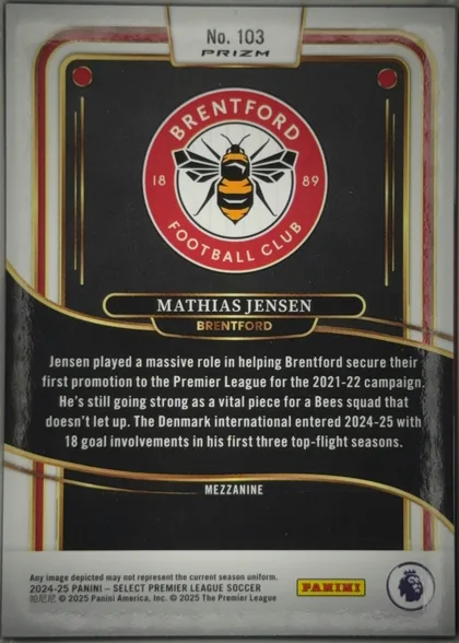 Back of 2024-25 Panini Select Premier League Soccer Mathias Jensen #103 Mezzanine Prizm, upright portrait-oriented card back. A black-and-gold decorative design fills most of the surface, with red, gold, and white border accents. The top…