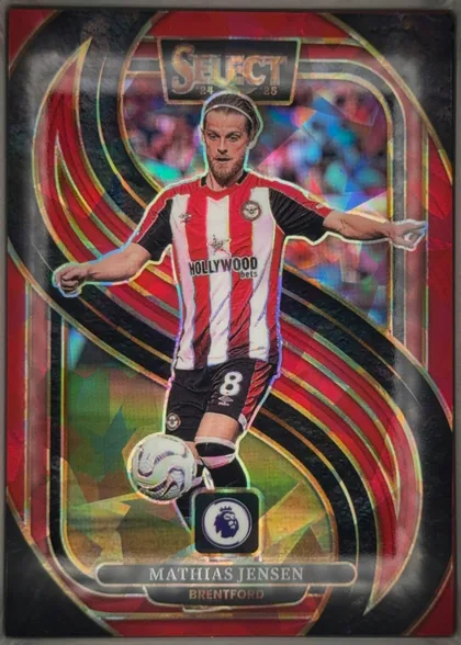 Front of 2024-25 Panini Select Premier League Soccer Mathias Jensen #103 Mezzanine Prizm, portrait soccer card front. A stylized illustrated/photographic image of Mathias Jensen in a red-and-white Brentford shirt fills the center, with…