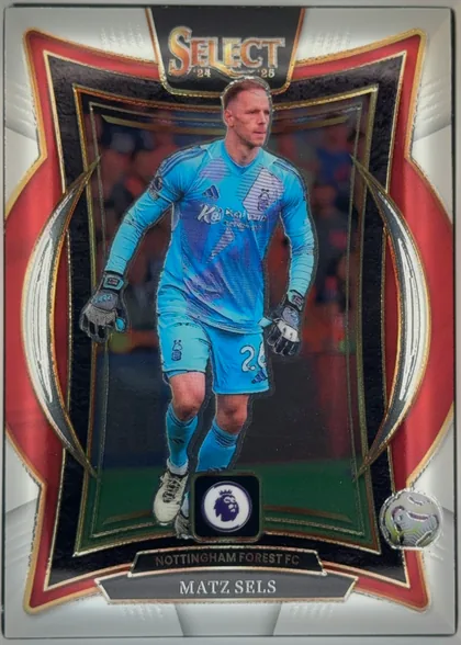 Front of 2024-25 Panini Select Premier League Soccer Matz Sels #75, front-facing portrait soccer card. A goalkeeper in a bright blue kit is centered in an action photograph. The large SELECT logo is at the top with…