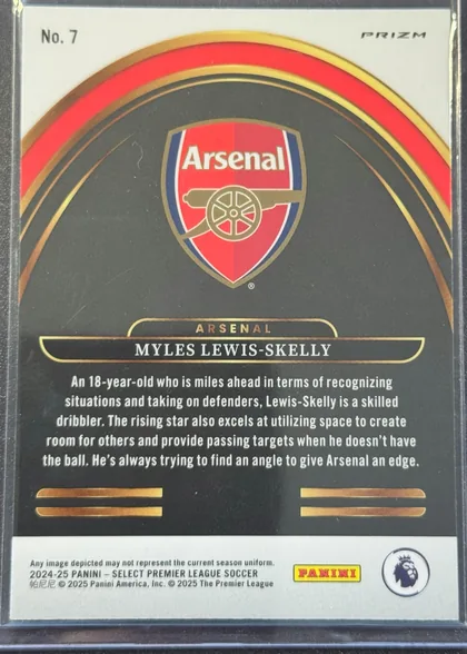 Back of 2024-25 Panini Select Premier League Soccer MYLES LEWIS-SKELLY #7 Silver Prizm, portrait-oriented card back with a white top and bottom panel surrounding a dark charcoal central field. The Arsenal crest is centered near the top…