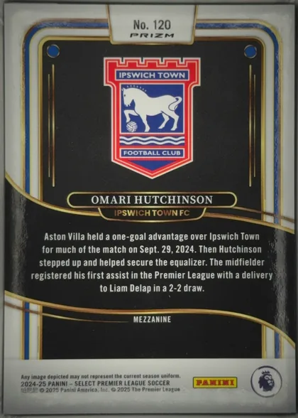 Back of 2024-25 Panini Select Premier League Soccer Omari Hutchinson #120 Mezzanine Prizm, upright portrait-format card back. A large Ipswich Town crest is centered in the upper half on a black background. The player name OMARI HUTCHINSON…