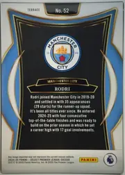 Back of 2024-25 Panini Select Premier League Soccer Rodri #52 Terrace, upright portrait-oriented card back. A white border surrounds an ornate blue, black, white, and gold frame. The Manchester City crest is centered…