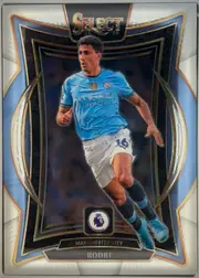 Front of 2024-25 Panini Select Premier League Soccer Rodri #52 Terrace, front-facing portrait soccer card. The top has a large SELECT logo with 24-25 beneath it. A player in a light blue Manchester City kit is pictured…