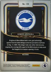 Back of 2024-25 Panini Select Premier League Soccer Simon Adingra #139 Mezzanine, upright portrait-format card back. A white border surrounds a black central field with blue, gold, and brown layered curved accents. The Brighton &…