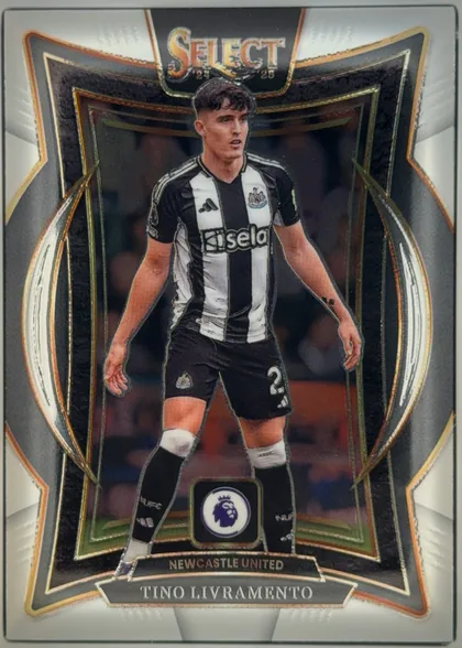 Front of 2024-25 Panini Select Premier League Soccer Tino Livramento #90 Terrace, upright portrait football card. A Newcastle United player in black-and-white kit is pictured full length against a dark stadium background. The top…