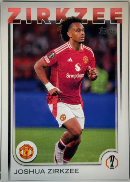 Front of 2024-25 Topps UEFA Club Competitions Soccer Joshua Zirkzee #121 Base, portrait-oriented soccer card front. A Manchester United player in a red kit appears in an action photograph, framed by a white border. The large…