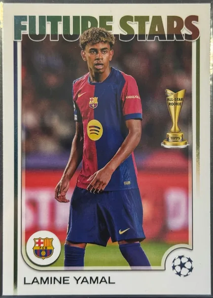 Front of 2024-25 Topps UEFA Club Competitions Soccer Lamine Yamal #27 Base, front of a soccer card. A bold sans-serif 'FUTURE STARS' title in a green-to-brown metallic gradient spans the top. The central photograph shows a…