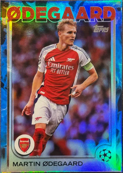 Front of 2024-25 Topps UEFA Club Competitions Soccer Martin ØDEGAARD #62 /125 numbered parallel; specific parallel name not printed, serial numbered 114/125, upright portrait soccer card front. Large red EDGE CARD lettering spans the top over a multicolored reflective foil background. A Topps logo…
