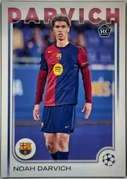 Front of 2024-25 Topps UEFA Club Competitions Soccer Noah Darvich #148 Base, portrait soccer card front. A full-body image of Noah Darvich in an FC Barcelona home kit occupies the center. Large red DARVICH lettering spans the…