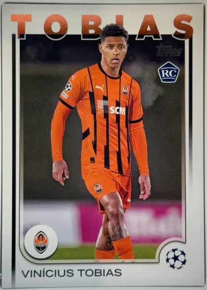 Front of 2024-25 Topps UEFA Club Competitions Soccer VINÍCIUS TOBIAS #167 Base, front of a soccer card. A white/silver frame surrounds a dark photographic window showing a player from the knees up, walking, wearing an…