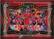 Front of 2024 Panini Select Premier League Dominik Szoboszlai #219 Prizm; Field Level, portrait-oriented soccer card front showing Dominik Szoboszlai in a red Liverpool FC kit running in front of a blurred multicolor stadium crowd. A…