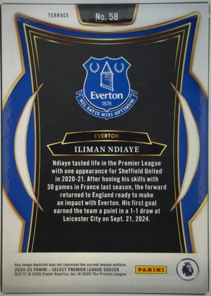 Back of 2024 Panini Select Premier League Iliman Ndiaye #58 Base Set Premier League Terrace, portrait-oriented card back. A white border surrounds a blue, black, gold, and cream ornamental frame. The Everton crest is centered in the upper…