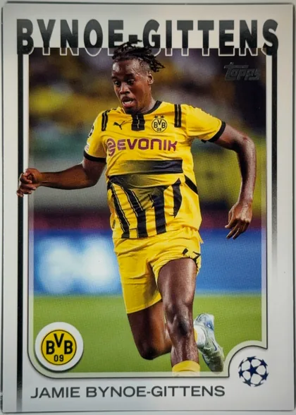 Front of 2024 Topps UEFA Jamie Bynoe-Gittens #58 Base, front of a soccer card. A full-bleed action photograph shows a Black male player with short dreadlocks running toward the camera, wearing a yellow…
