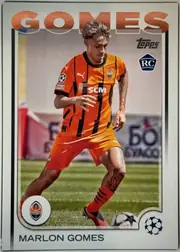 Front of 2024 Topps UEFA Marlon Gomes #30 Base, front of a soccer card. A full-body action photograph shows a player in an orange-and-black vertically striped Shakhtar Donetsk jersey (Puma logo…