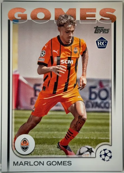 Front of 2024 Topps UEFA Marlon Gomes #30 Base, front of a soccer card. A full-body action photograph shows a player in an orange-and-black vertically striped Shakhtar Donetsk jersey (Puma logo…