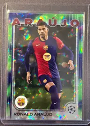 Front of 2024 Topps UEFA Ronald Araújo #24 Base, portrait soccer card front. Large red uppercase ARAUJO text spans the top. A player in an FC Barcelona red-and-blue kit is shown centrally against a…