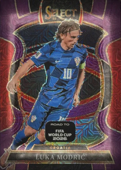 Front of 2025-26 Panini Select Road to FIFA World Cup 2026 Soccer Luka Modrić #35 Refractor, front of a soccer card. Top center: gold foil "SELECT" wordmark with a small "'26" below it. Center: a die-cut action photo of a male player in a…