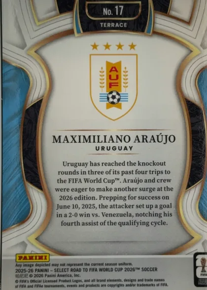 Back of 2025-26 Panini - Select Road to FIFA World Cup 2026 Soccer MAXIMILIANO ARAÚJO #17 Terrace, upright portrait-oriented card back. A large ornate white and light-gray central panel is framed by gold, bronze, black textured, and blue geometric…