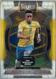 Front of 2025-26 Panini - Select Road to FIFA World Cup 2026 Soccer VINI JR. #99 Base Terrace, front side. At top center is the gold-to-orange gradient 'SELECT' wordmark with small '25 and '26 markers below it. The central artwork is a…