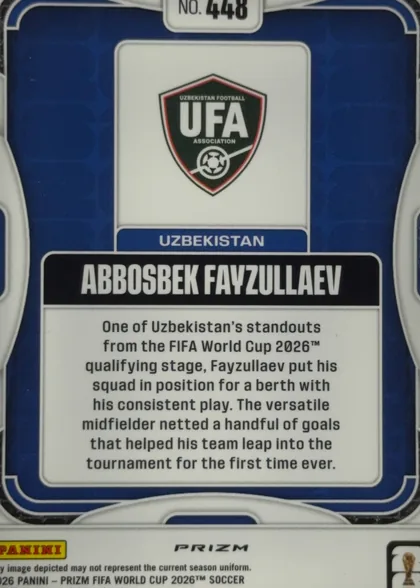 Back of 2026 Panini Prizm FIFA Abbosbek Fayzullaev #448, upright portrait-oriented card back. A dark blue field is framed by white and silver rounded border graphics. At the top center is a white number…
