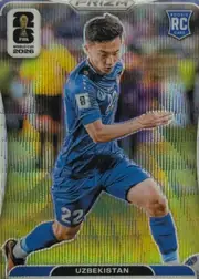 Front of 2026 Panini Prizm FIFA Abbosbek Fayzullaev #448, front of a soccer card. A male player in a blue Uzbekistan kit (number 22 on the shorts and chest) is shown in a running pose, die-cut against a…