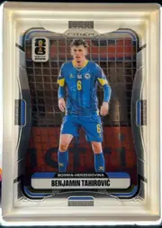 Front of 2026 Panini Prizm FIFA Benjamin Tahirovic #472 Base, portrait-format soccer card front. A full-body image of Benjamin Tahirovic in a blue Bosnia-Herzegovina kit stands in front of a soccer goal net…