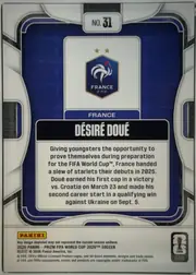Back of 2026 Panini Prizm FIFA DÉSIRÉ DOUÉ #31 Base, upright portrait-format card back. A white and silver geometric outer design surrounds a dark blue inset panel with rounded corners and thin black…