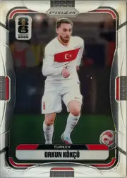 Front of 2026 Panini Prizm FIFA Orkun Kökçü #485 Base Prizm, upright portrait-format soccer card front. A full-body image of a Turkey player in a white national-team kit appears against a dark stadium…