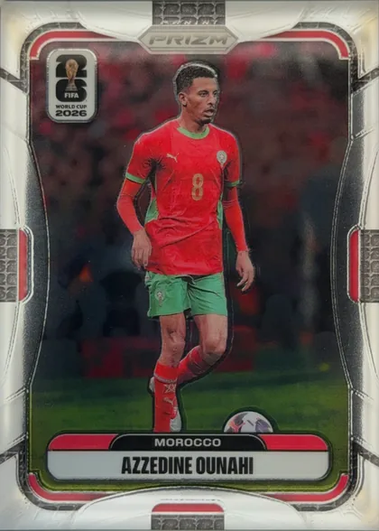 Front of 2026 Panini Prizm FIFA Soccer Cards Azzedine Ounahi #297, portrait soccer card front. Azzedine Ounahi is shown standing in a Morocco red-and-green uniform on a dark red and black stadium background. The…