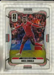 Front of 2026 Panini Prizm FIFA Soccer Cards Breel Embolo #420 Prizm refractor, front of a Prizm soccer card. A full-body cutout photo of a player in a red Switzerland kit (number 7) with arms outstretched, set against a blurred…