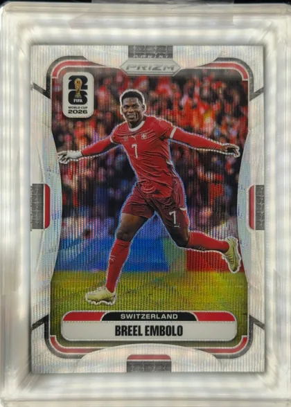 Front of 2026 Panini Prizm FIFA Soccer Cards Breel Embolo #420 Prizm refractor, front of a Prizm soccer card. A full-body cutout photo of a player in a red Switzerland kit (number 7) with arms outstretched, set against a blurred…