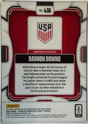 Back of 2026 Panini Prizm FIFA Soccer Cards Damion Downs #436, upright portrait-oriented card back. A red and black patterned central panel is surrounded by a white and black geometric frame. The top center has…