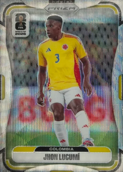 Front of 2026 Panini Prizm FIFA Soccer Cards Jhon Lucumí #184, portrait soccer card front. A player in a yellow Colombia jersey with number 3 is shown on a soccer field. The top center has a PRIZM logo, the…