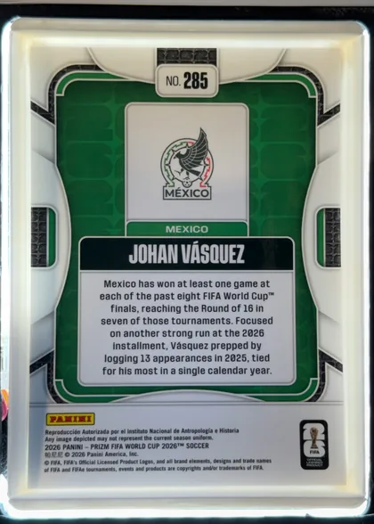 Back of 2026 Panini Prizm FIFA Soccer Cards Johan Vásquez #285 Prizm (base refractor), back side, portrait orientation. Top center is a white tab reading 'NO. 285'. Below is a green textured field containing a white panel with the…