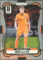 Front of 2026 Panini Prizm FIFA Soccer Cards Micky van de Ven #316, portrait soccer card front. A Netherlands player in an orange national-team uniform is pictured centrally on a soccer-field background. The card has…