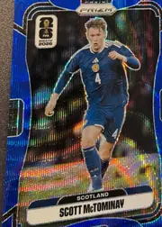 Front of 2026 Panini Prizm FIFA Soccer Cards Scott McTominay #393 Blue prismatic foil, portrait-format soccer card front. A full-body image of Scott McTominay in a blue Scotland kit occupies the center, with number 4 visible on the…