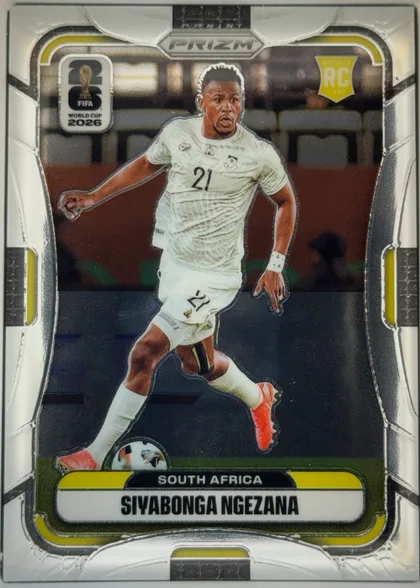 Front of 2026 Panini Prizm FIFA Soccer Cards Siyabonga Ngezana #412, portrait-oriented soccer card front. A player in a white South Africa kit is shown running with the ball against a stadium background. The top has…
