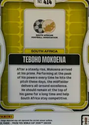Back of 2026 Panini Prizm FIFA Soccer Cards Teboho Mokoena #414, upright portrait-oriented card back. A gold/yellow geometric patterned field is enclosed by a white and gray rounded border. At the top center is a…