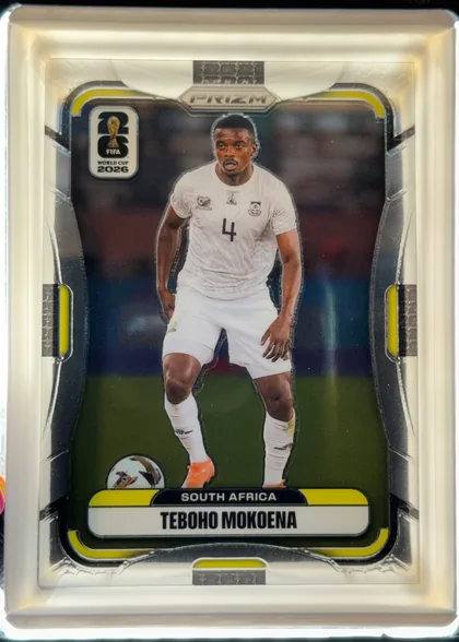 Front of 2026 Panini Prizm FIFA Soccer Cards Teboho Mokoena #414, portrait-oriented front with a central full-body soccer player image in a white South Africa uniform, dark stadium background, yellow and…