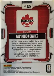 Back of 2026 Panini Prizm FIFA World Cup Soccer Alphonso Davies #165, upright portrait-oriented card back. A red Canada-themed central panel is surrounded by white, gray, and black geometric borders. The card number…