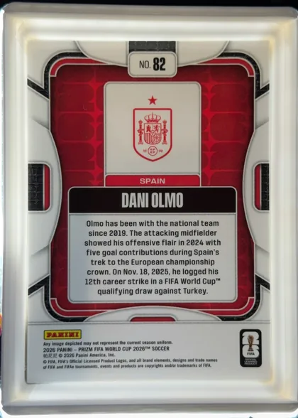 Back of 2026 Panini Prizm FIFA World Cup Soccer DANI OLMO #82 Base, portrait-format card back with a predominantly white and light-gray outer frame. A black and red rounded rectangular frame surrounds a red patterned…
