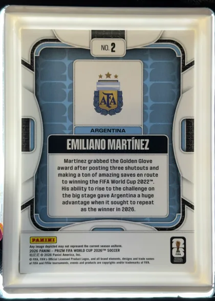 Back of 2026 Panini Prizm FIFA World Cup Soccer Emiliano Martínez #2 Base, upright portrait-oriented card back. A small rounded label at the top reads NO. 2. The Argentina crest with three stars is centered above the team…