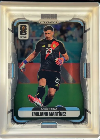 Front of 2026 Panini Prizm FIFA World Cup Soccer Emiliano Martínez #2 Base, upright portrait soccer card front. A centered photograph shows Emiliano Martinez in Argentina's black goalkeeper kit, with the number 23 visible…