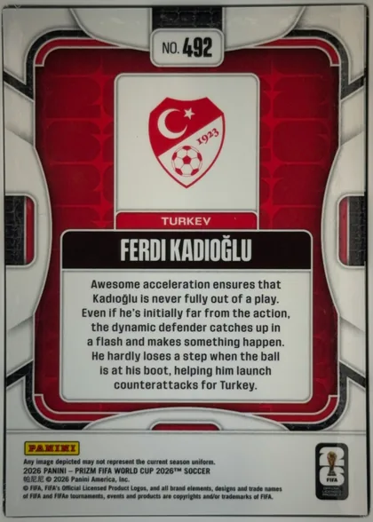 Back of 2026 Panini Prizm FIFA World Cup Soccer Ferdi Kadıoğlu #492 Base, upright portrait-oriented card back. A red patterned central field is framed by white, black, and gray geometric borders. At the top center is a…