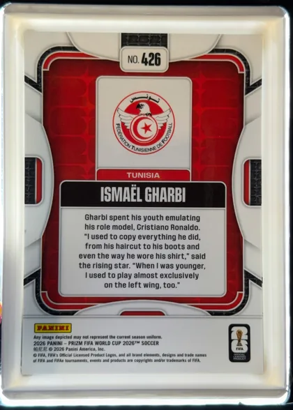Back of 2026 Panini Prizm FIFA World Cup Soccer ISMAËL GHARBI #426, portrait-oriented card back. A white and gray mechanical-style frame surrounds a red patterned central panel. The card number appears in a white…