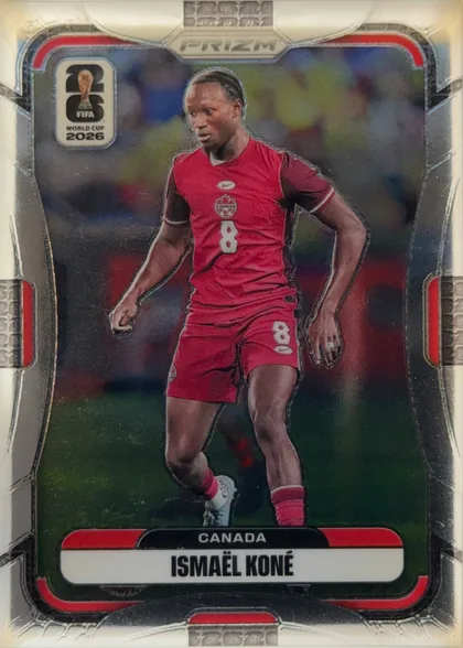 Front of 2026 Panini Prizm FIFA World Cup Soccer Ismael Koné #169 Base, upright portrait soccer card front. A player in a red Canada uniform is shown in action against a blurred stadium background. The FIFA World Cup…