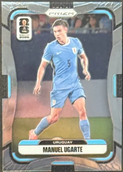 Front of 2026 Panini Prizm FIFA World Cup Soccer Manuel Ugarte #124 Base, portrait soccer card front. A full-body photograph of Manuel Ugarte in a light blue Uruguay kit occupies the central image area. The top center has…