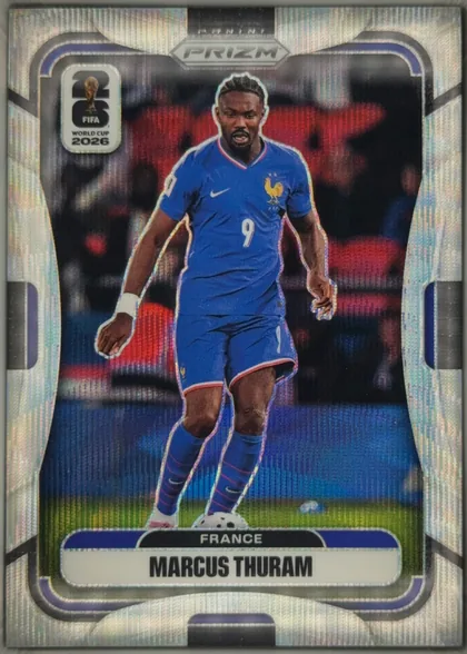 Front of 2026 Panini Prizm FIFA World Cup Soccer Marcus Thuram #26, front of a Panini Prizm soccer card. Top center has a small 'PANINI' wordmark above a hexagonal 'PRIZM' badge. Top left carries a white rounded logo…